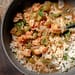 Bowl of steaming étouffée with shrimp and crawfish over white rice, garnished with green onions